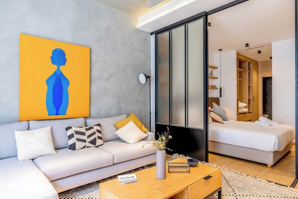 A modern living room with a sofa, coffee table, and a painting on the wall. - Stayhere Casablanca - Gauthier Loft Living (Casablanca)
