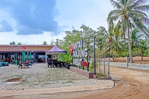A café named 'Café Daniel' with outdoor seating and a sign for 'Tanjung Amap Best'.