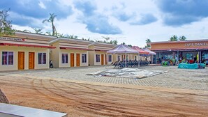 A hotel courtyard with multiple rooms, a covered seating area, and a cafe.