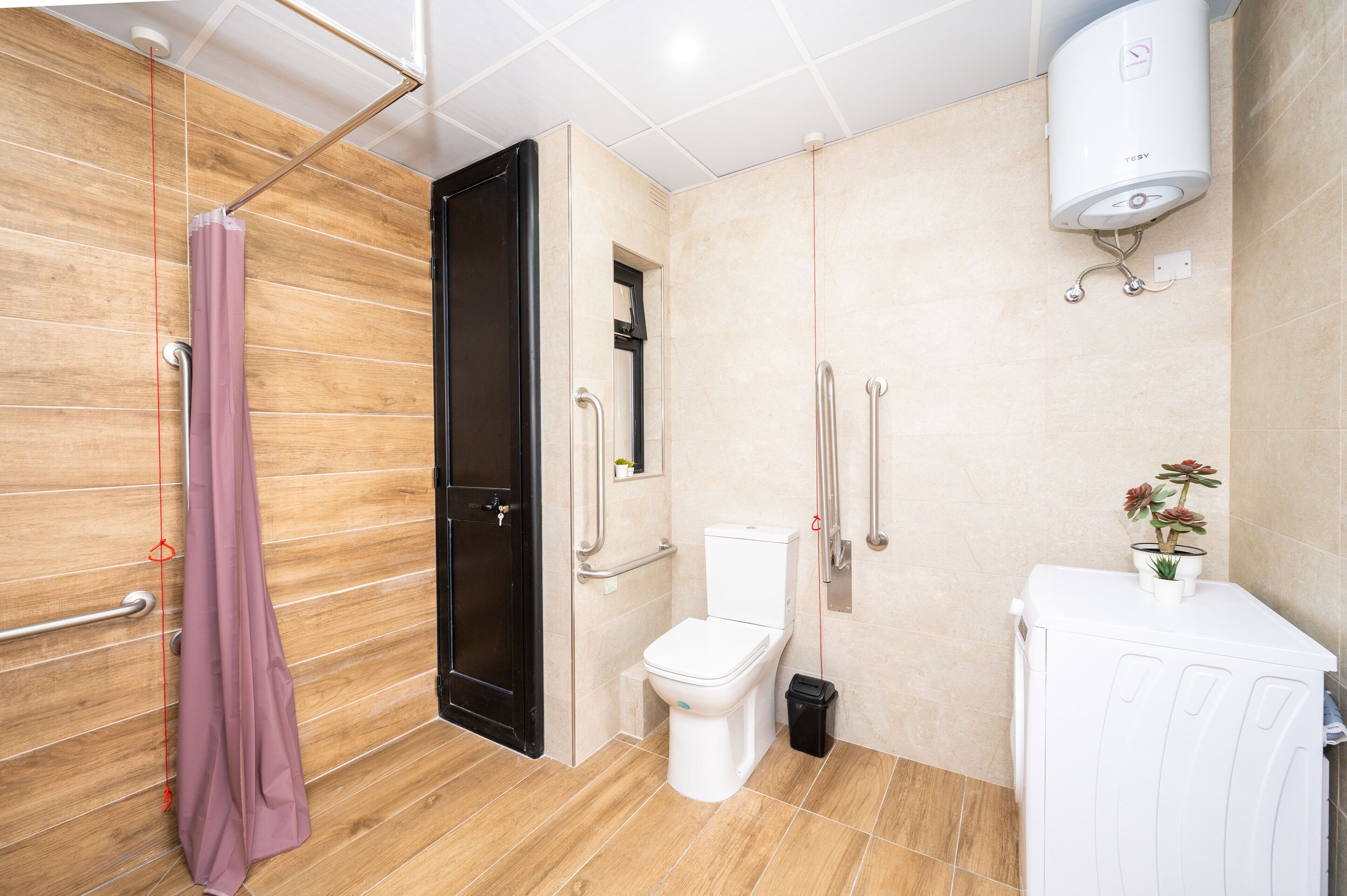 Ein modernes Badezimmer mit Toilette, einer Duschkabine, einem Handtuchhalter und einem Wandheizkörper.