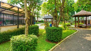 A garden area with a gazebo, a pathway, and neatly trimmed bushes. - Capital O 91651 Independent99 Near Kalibata city square (Jakarta)