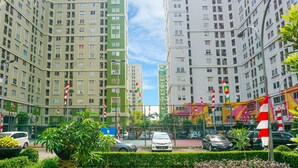 A view of high-rise residential buildings with balconies, a street with parked cars, and a clear sky. - Capital O 91651 Independent99 Near Kalibata city square (Jakarta)