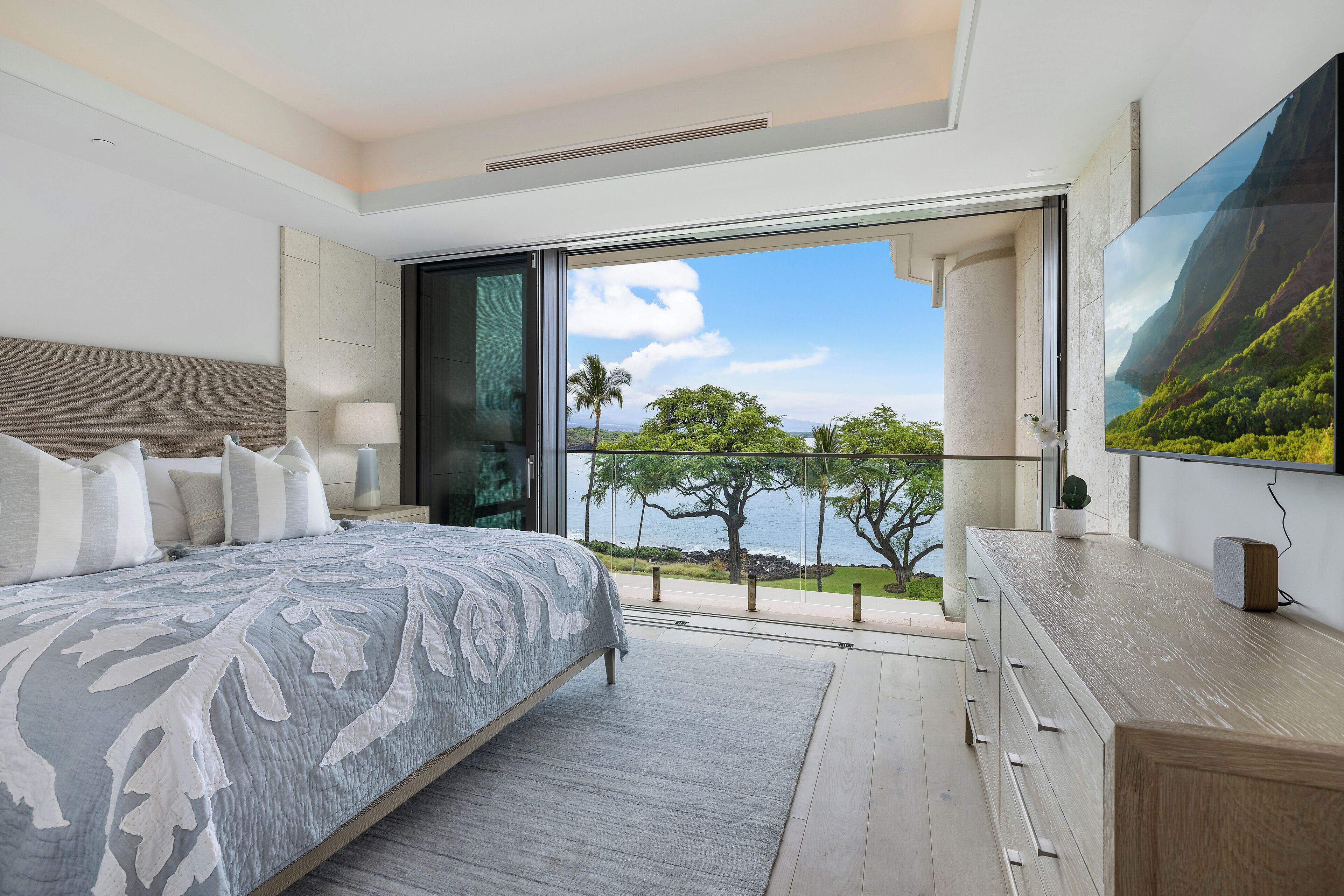 Une chambre moderne avec un grand lit, une télévision et un balcon offrant une vue panoramique.