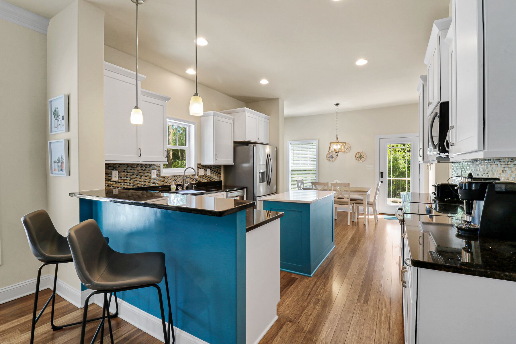 A modern kitchen with a central island, white cabinets, and a blue accent wall.