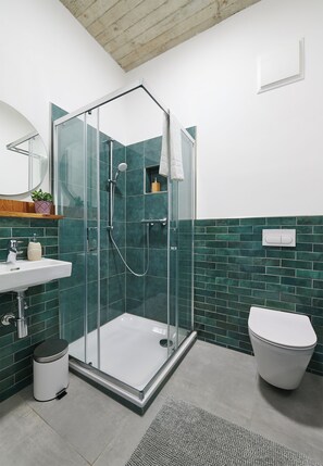 A modern bathroom with a glass-enclosed shower, a white sink, and a toilet. - PHIL & MAX Hotel & Apartments  Airport (Langenhagen)