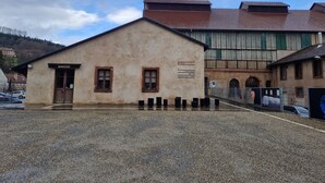 Ein Gebäude mit einem Schild, auf dem 'MAGASIN' steht, und einem weiteren Schild, das zu 'MUSEE' und 'COMPTOIR DE LA MANUFACTURE' weist.