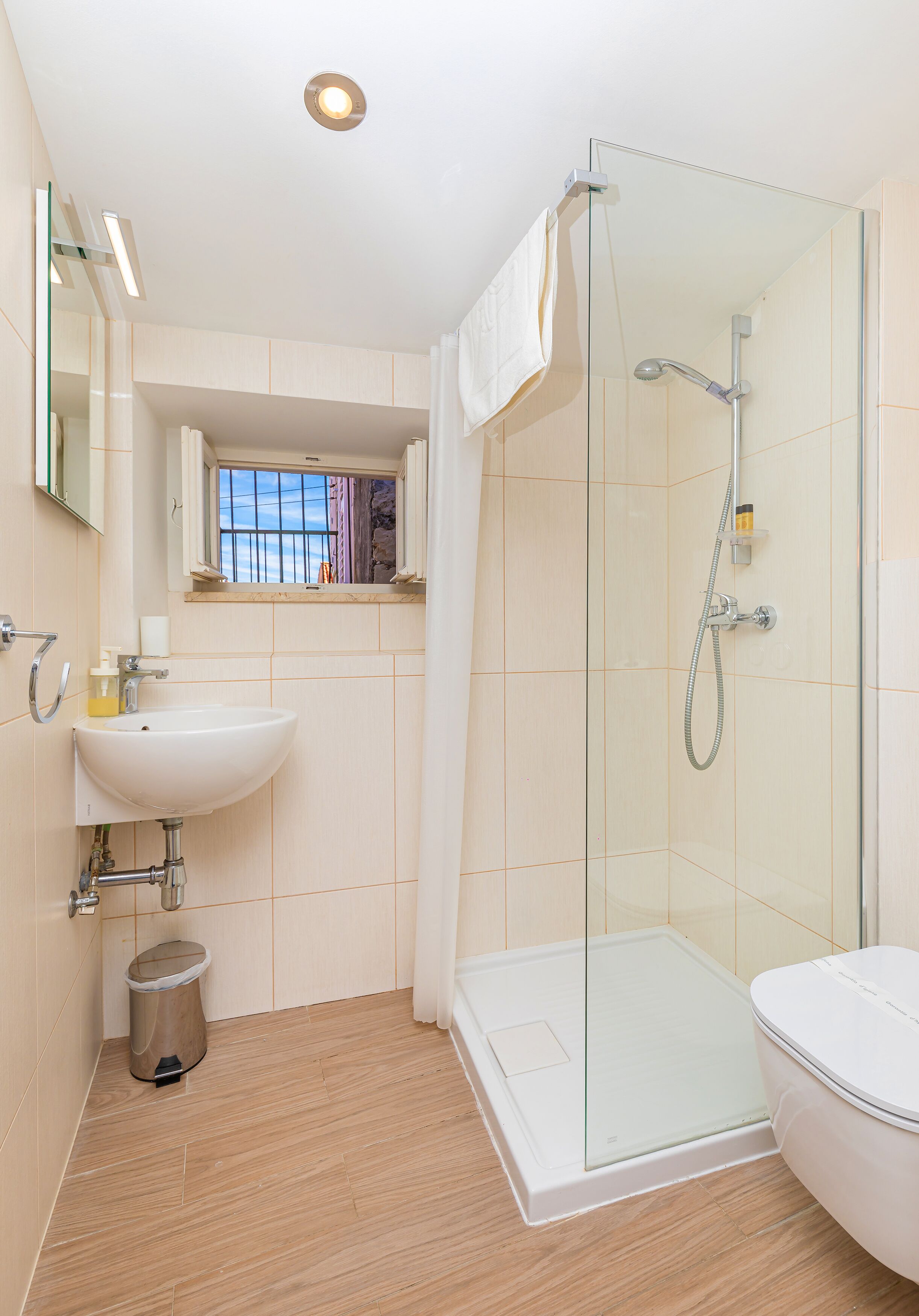 Une salle de bain moderne avec une douche à parois de verre, un lavabo blanc et des toilettes.