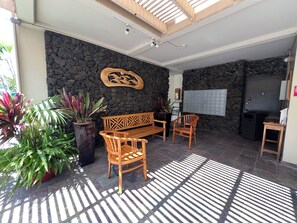 A reception area with a stone wall, wooden furniture, and potted plants.
