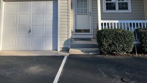A two-story house with a garage, a front porch, and a small front yard.