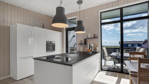 Una cocina moderna con una isla central, electrodomésticos de acero inoxidable y un ventanal con vistas panorámicas.