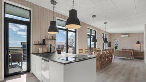Una cocina moderna con una isla central, ventanas amplias y vistas al exterior.