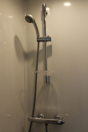 A shower with a handheld showerhead and a wall-mounted faucet. - Hôtel de la Gare (Saint-Amand)