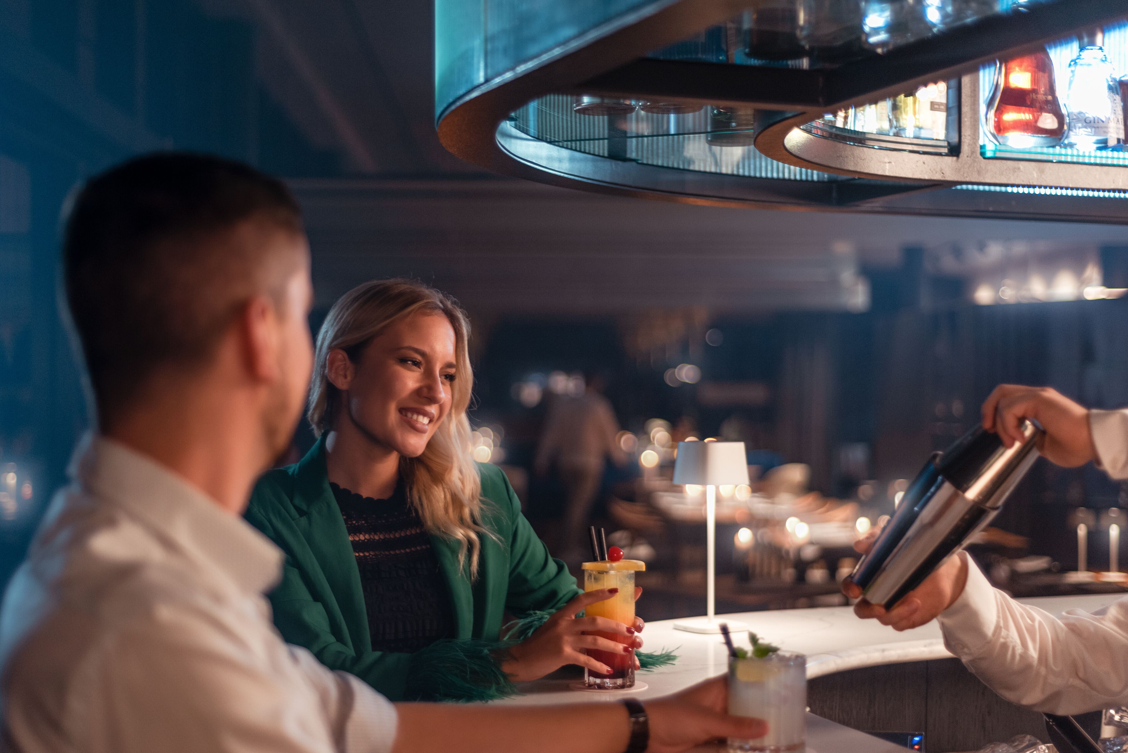 Een bar waarin iemand een drankje in een glas schenkt.
