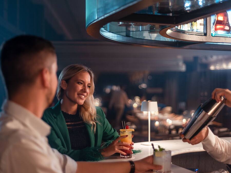 Een bar waarin iemand een drankje in een glas schenkt.