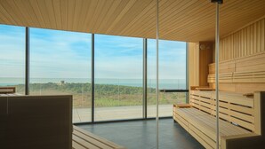 Un interior moderno con ventanas amplias, bancos de madera y vistas al paisaje.