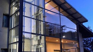 A modern building with large glass windows and a sloped roof. - NAOUSSA MOUNTAIN RESORT (Naousa)