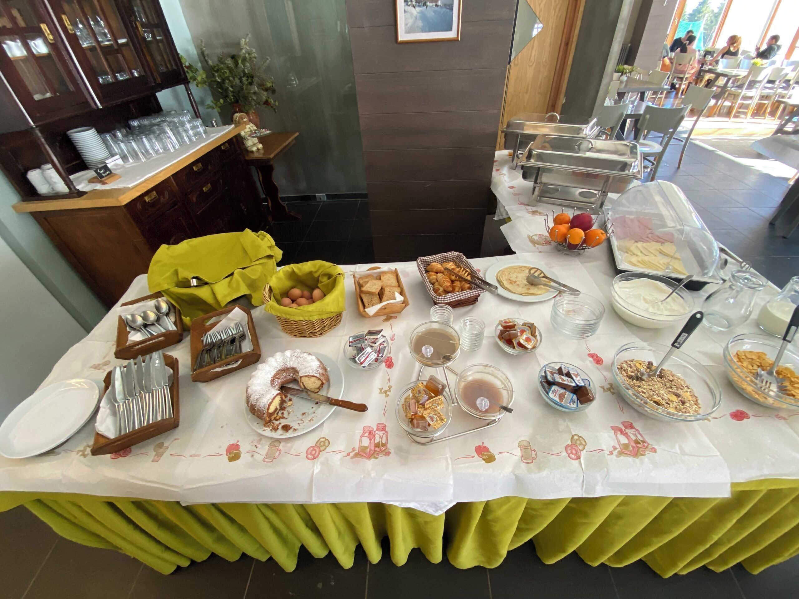 A buffet table with various food items and utensils.