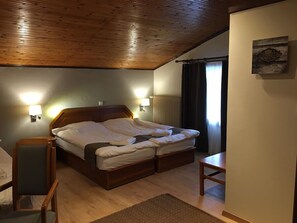 A bedroom with a wooden ceiling, a large bed with white linens, two wall-mounted lamps, and a small table. - NAOUSSA MOUNTAIN RESORT (Naousa)