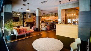 A modern hotel lobby with a reception desk, seating area, and a bar. - NAOUSSA MOUNTAIN RESORT (Naousa)