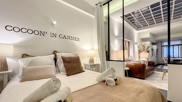 Een hotelkamer met een bed, een bureau, een bank en een groot raam.