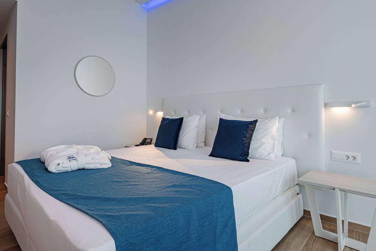 Un dormitorio moderno con una cama grande, una mesita de noche y un aplique de pared.