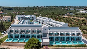 Een modern hotel met meerdere zwembaden en uitzicht op het omliggende landschap.