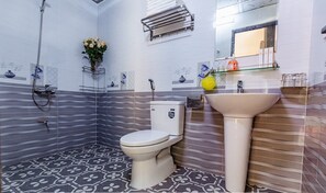 A bathroom with a toilet, a sink, a shower, and a towel rack. - Tam Coc Minh Hung Homestay (Nam Hoa Lu)