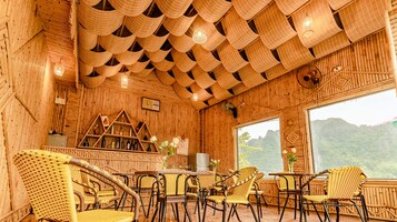 A bamboo-themed interior with wicker furniture, a fireplace, and a view of mountains.