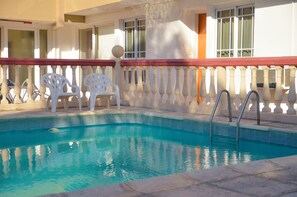 Una piscina cubierta, una piscina al aire libre, sombrillas, tumbonas