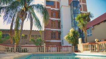 Een binnenzwembad, een buitenzwembad, parasols voor strand/zwembad