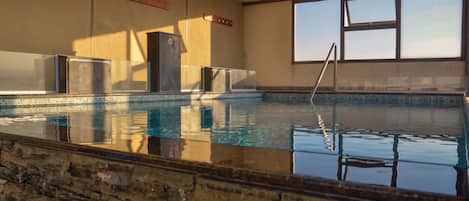 Piscine couverte, piscine extérieure, parasols de plage, chaises longues