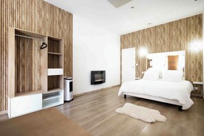 A modern bedroom with a bed, a TV, a wardrobe, and a heater. - SPA CENTER Saint-Quentin (Saint-Quentin)