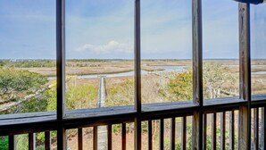 Blick aus einem Fenster mit Holzrahmen auf eine Landschaft mit Gewässern und Vegetation.