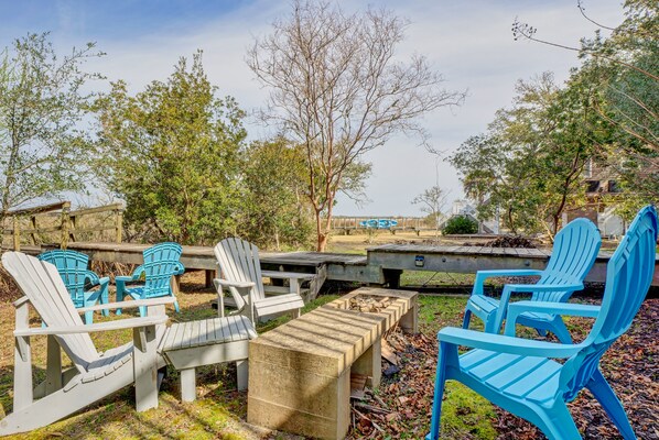 An outdoor seating area with Adirondack chairs and a fire pit.