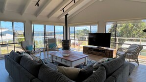 A spacious living room with a large sofa, a coffee table, a TV, and a fireplace. - Seabreeze At Shalfleet (Ventnor)
