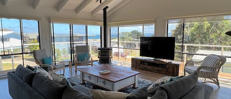 Ein geräumiges Wohnzimmer mit einem großen Sofa, einem Couchtisch, einem Fernseher und einem Kamin.