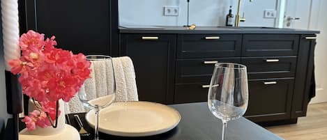 Een moderne keuken met donkere kastjes, een inbouwoven en een roestvrijstalen afzuigkap.