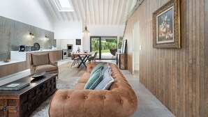 Un intérieur moderne comprenant un coin repas, une cuisine et une grande fenêtre donnant sur un jardin.