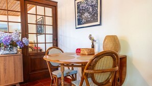 Un comedor con una mesa de madera, sillas de mimbre y una cesta de mimbre.