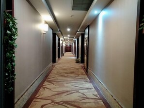 A hotel hallway with carpeted floors, walls, and ceiling lights. - Greentree Alliance Nanjing Yuhuatai District Nanjing South Station Hotel (Nanjing)