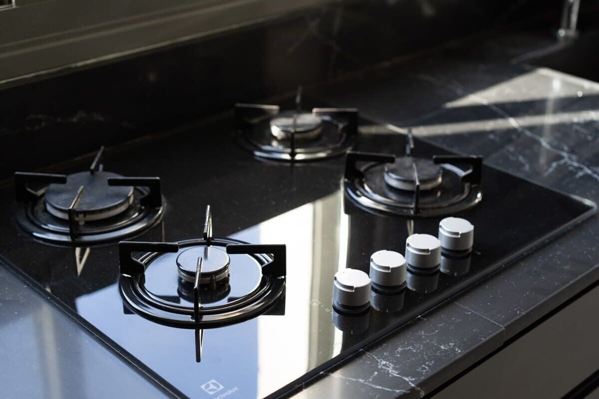 A gas stove with four burners and a control panel with knobs.