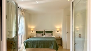 A bedroom with a bed, two bedside tables, and a wardrobe.