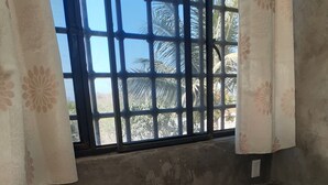 A kitchen with a gas stove, sink, and wooden shelves with kitchen items. - Bungalow loft with large garden and rural area close to all amenities (Puerto Vallarta)