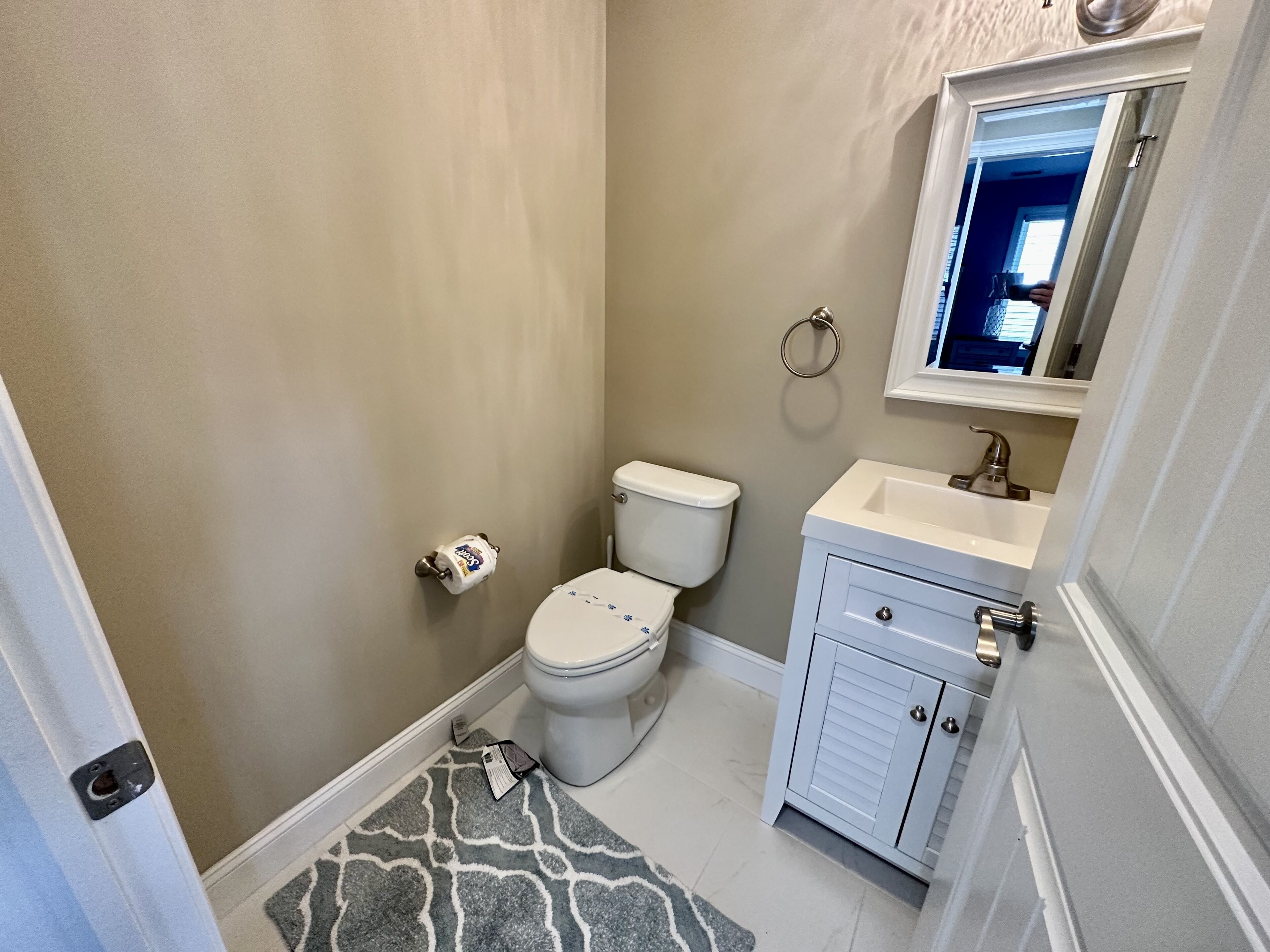 Une petite salle de bain avec des toilettes, un lavabo et un miroir.