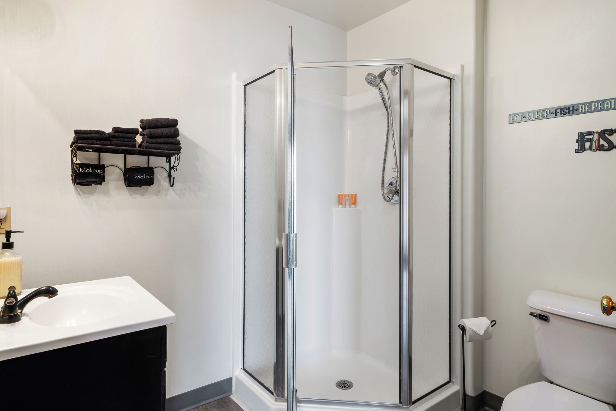 Une salle de bain moderne avec une douche à parois de verre, un lavabo blanc et des toilettes.