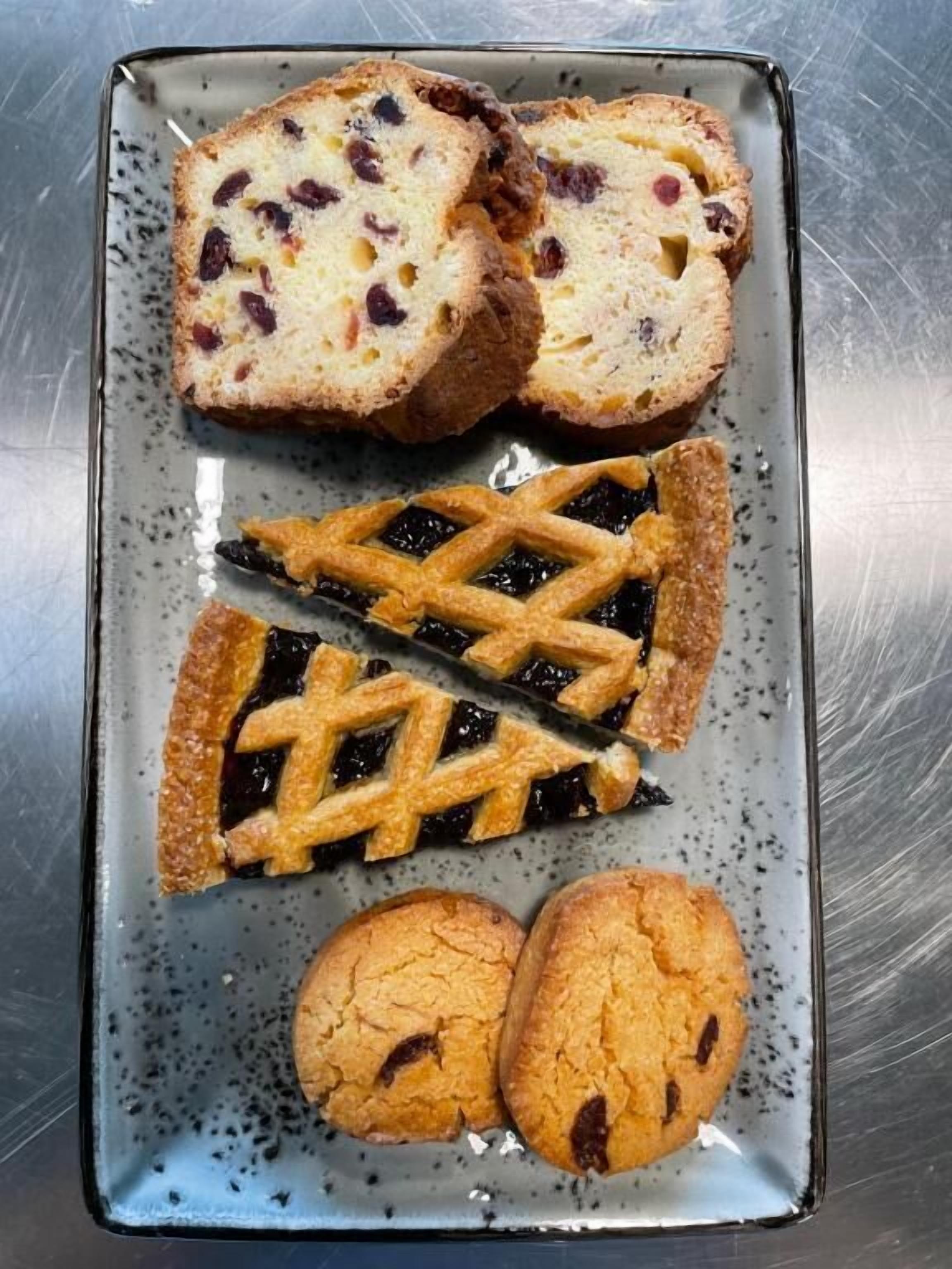 A tray with slices of bread, a pie, and two cookies.