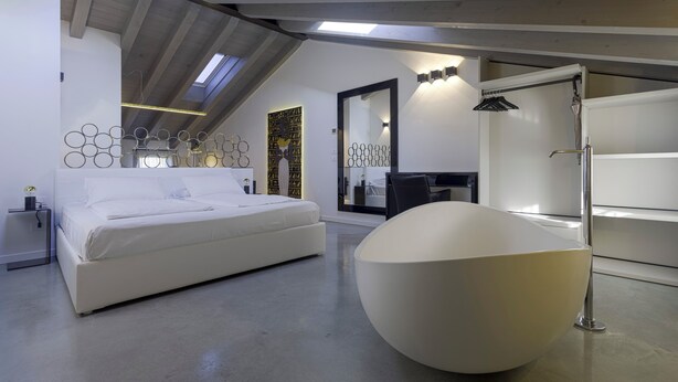A modern bedroom with a large bed, a unique spherical sink, and a skylight. - Agriturismo Redó (Ponti sul Mincio)