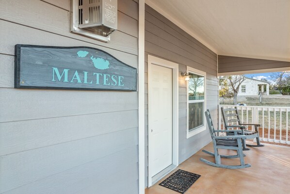 A porch with a sign reading "MALTSE," a white door, and two rocking chairs. - Private Hot Tub - Fireplace - 4 min. to downtown - Wildlife (Fredericksburg)