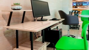 A modern office space with a desk, computer, and green chairs. - Greentree Inn Jiangsu Suzhou Zhangjiagang Tangshi Town Yangzi Road Express Hotel (Suzhou)