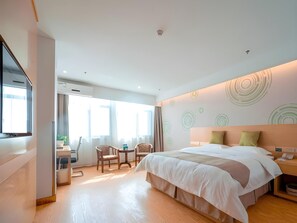 A modern hotel room with a large bed, a desk with a chair, and a small table. - Greentree Inn Jiangsu Suzhou Zhangjiagang Tangshi Town Yangzi Road Express Hotel (Suzhou)